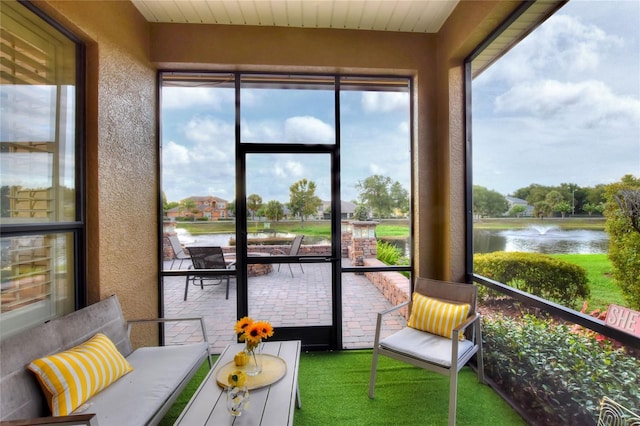 sunroom featuring a water view