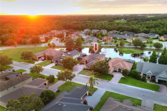 aerial view at dusk featuring a water view