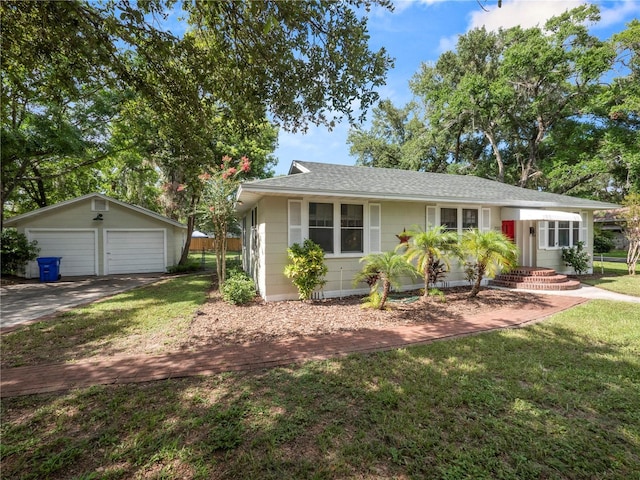 single story home featuring a garage, an outbuilding, and a front lawn