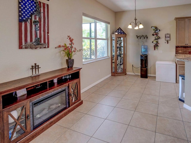 kitchen featuring backsplash, light stone countertops, light tile patterned floors, and a chandelier