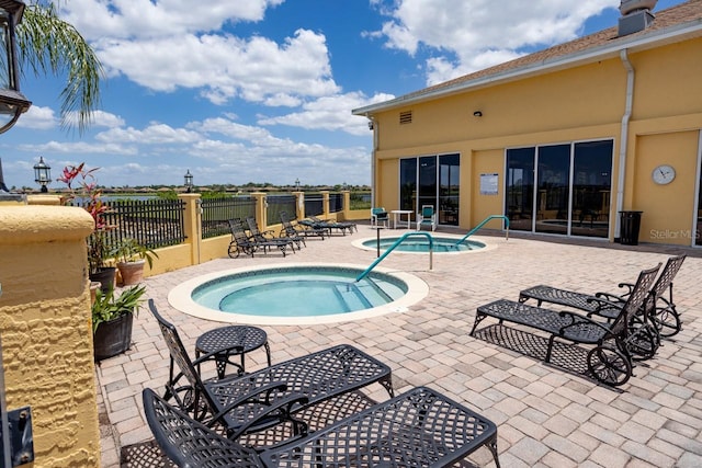 view of swimming pool featuring a hot tub and a patio area