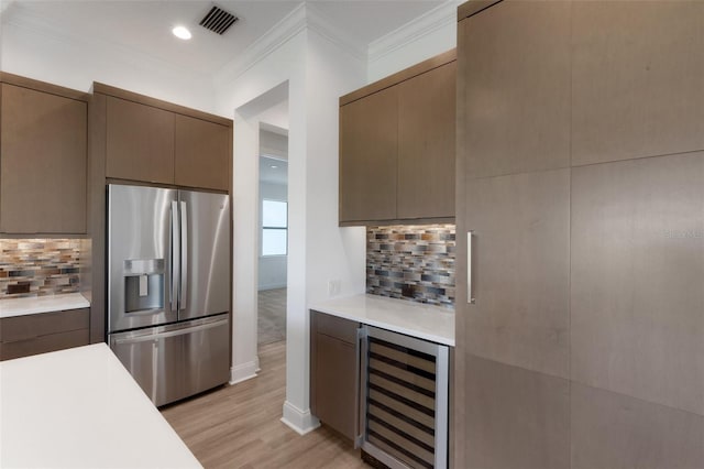 kitchen featuring stainless steel refrigerator with ice dispenser, decorative backsplash, light wood-type flooring, and wine cooler