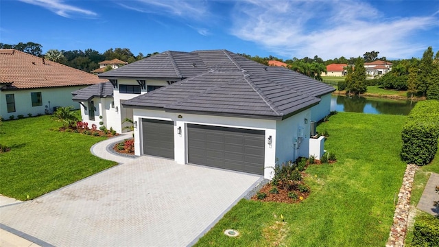 view of front of property featuring a water view, a garage, and a front yard