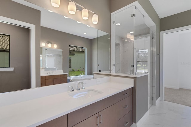 bathroom featuring a shower with shower door and vanity