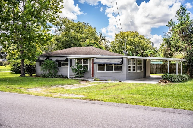 view of front of home with a carport and a front lawn