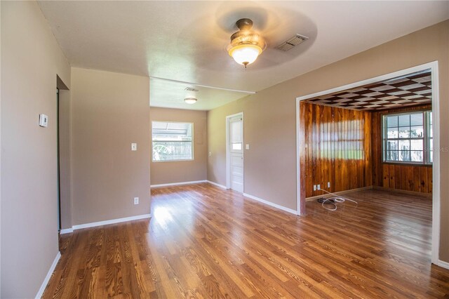 spare room with ceiling fan, a healthy amount of sunlight, and wood-type flooring