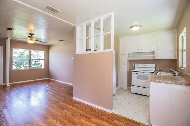 kitchen with sink, light hardwood / wood-style flooring, ceiling fan, and white range with electric stovetop