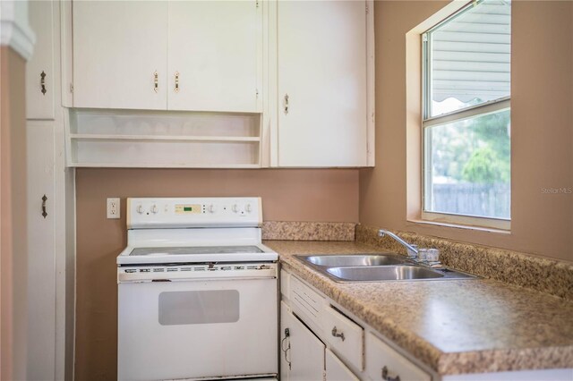 kitchen featuring sink, white cabinets, and white electric range