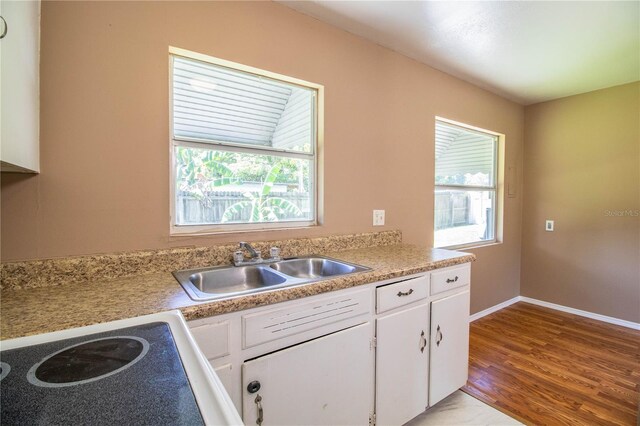 kitchen with sink, white cabinetry, and light wood-type flooring