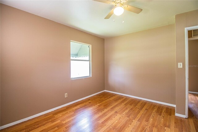 spare room with hardwood / wood-style flooring and ceiling fan