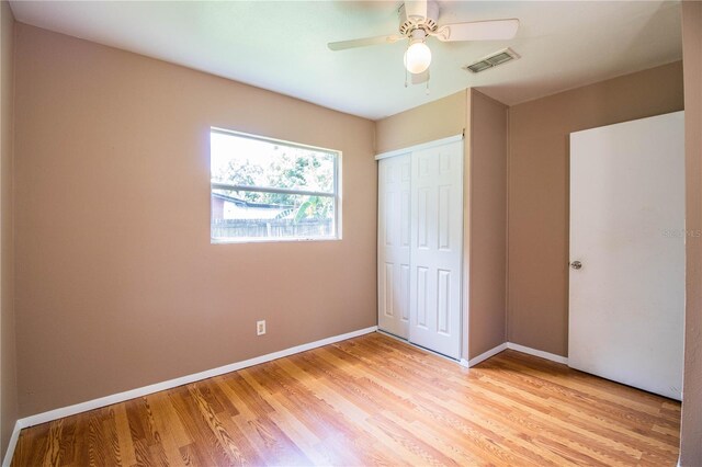 unfurnished bedroom with light hardwood / wood-style floors, a closet, and ceiling fan