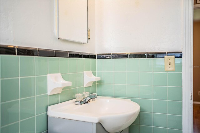 bathroom with backsplash, tile walls, and sink