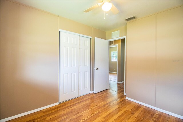 unfurnished bedroom with ceiling fan and light wood-type flooring