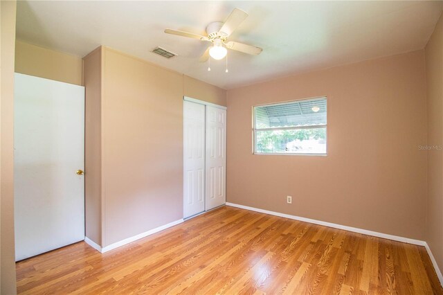 unfurnished bedroom featuring light hardwood / wood-style floors, a closet, and ceiling fan