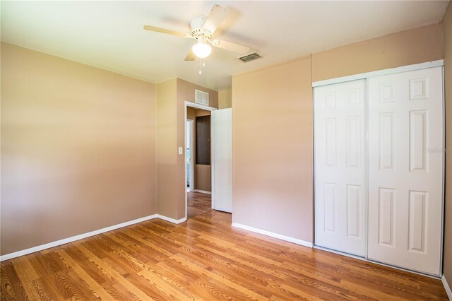 unfurnished bedroom featuring ceiling fan, a closet, and light hardwood / wood-style flooring