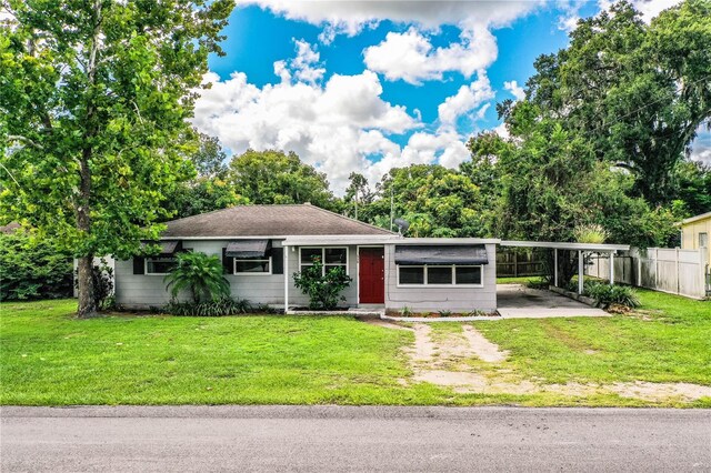 ranch-style house featuring a carport and a front yard