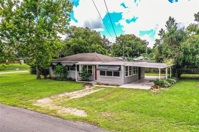 view of front facade with a front lawn and a carport