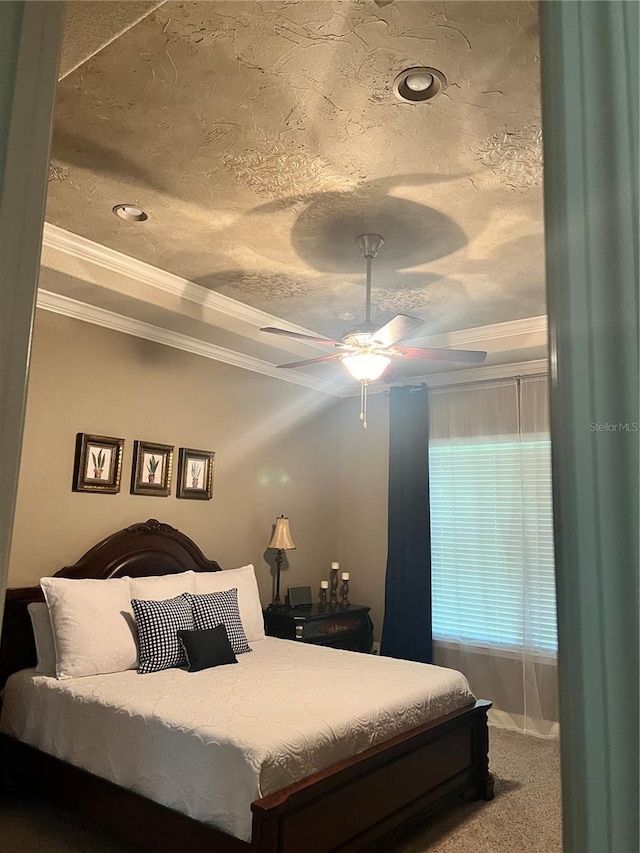 carpeted bedroom with ceiling fan, a textured ceiling, and ornamental molding