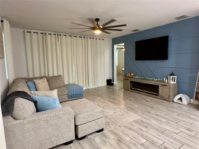 living room featuring light hardwood / wood-style flooring and ceiling fan