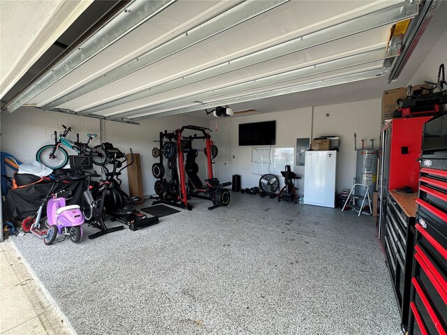 garage with a garage door opener, electric water heater, electric panel, and white fridge