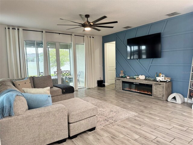 living room featuring ceiling fan and light hardwood / wood-style floors