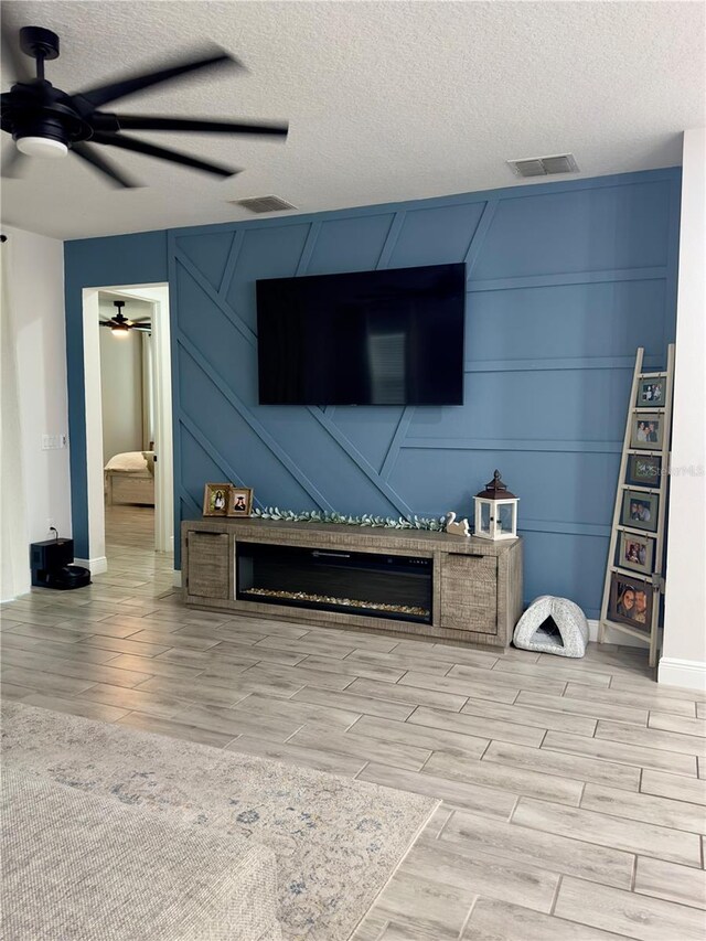 exterior space with ceiling fan, light hardwood / wood-style flooring, and a textured ceiling