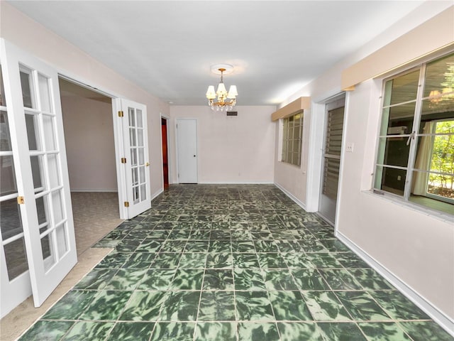 corridor featuring a notable chandelier and french doors