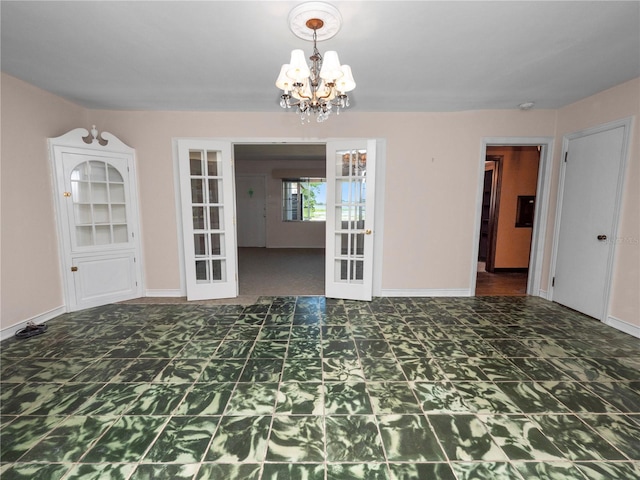 unfurnished dining area with dark colored carpet, a chandelier, and french doors