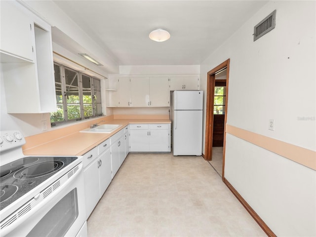 kitchen featuring a wealth of natural light, sink, white cabinets, and white appliances