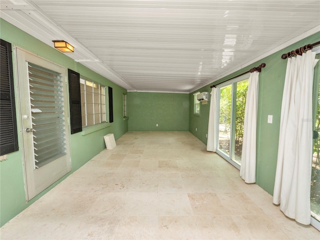 unfurnished sunroom with an AC wall unit