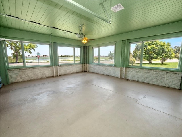 unfurnished sunroom featuring ceiling fan and a healthy amount of sunlight