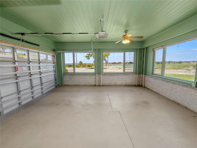 unfurnished sunroom featuring ceiling fan