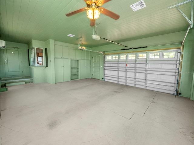 garage featuring a wall mounted AC, ceiling fan, and a garage door opener