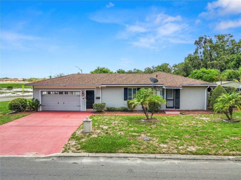 ranch-style home featuring a front lawn and a garage