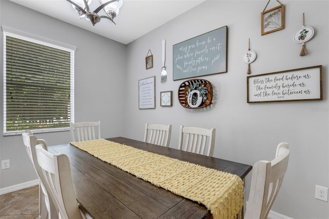 dining space featuring tile patterned flooring and a notable chandelier