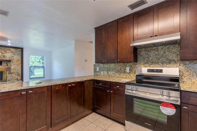 kitchen with kitchen peninsula, light stone countertops, wall chimney exhaust hood, decorative backsplash, and electric range