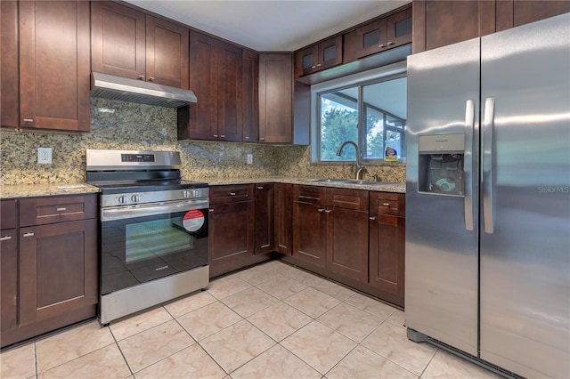 kitchen with sink, light stone counters, light tile patterned flooring, decorative backsplash, and appliances with stainless steel finishes