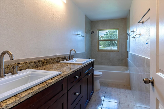 full bathroom featuring toilet, tiled shower / bath, and vanity