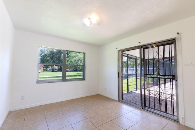 unfurnished room with light tile patterned flooring and plenty of natural light