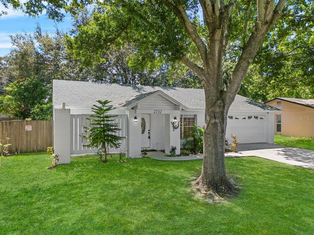 single story home featuring a garage and a front yard