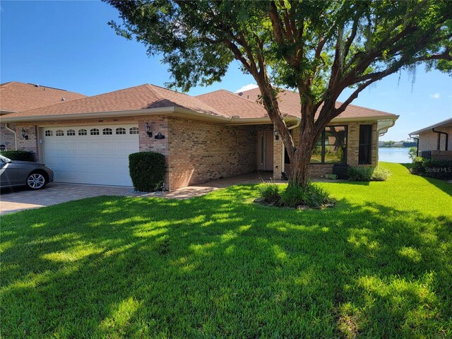 ranch-style home with a water view, a garage, and a front lawn