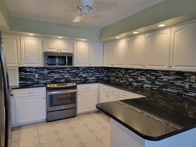 kitchen featuring ceiling fan, tasteful backsplash, kitchen peninsula, white cabinets, and appliances with stainless steel finishes