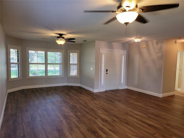 foyer featuring dark wood-type flooring, a ceiling fan, baseboards, and a textured ceiling