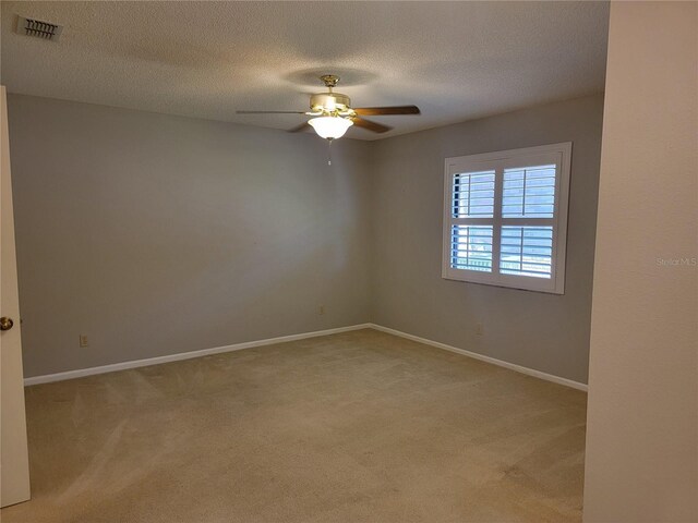 carpeted empty room featuring a textured ceiling and ceiling fan