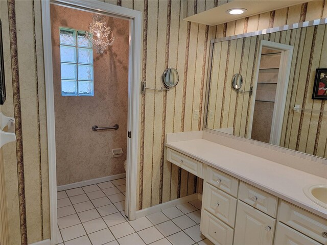 bathroom with tile patterned floors, vanity, toilet, and a chandelier