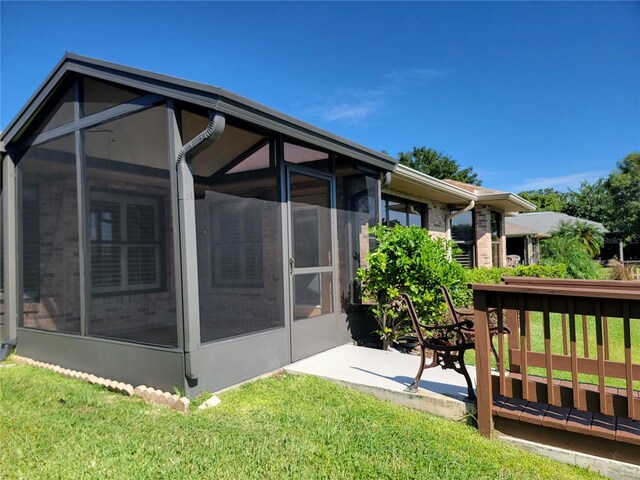 back of house with a lawn and a sunroom