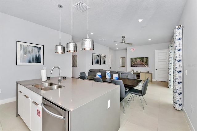 kitchen with stainless steel dishwasher, ceiling fan, sink, white cabinetry, and an island with sink