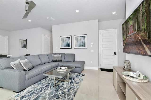 tiled living room featuring ceiling fan and a textured ceiling