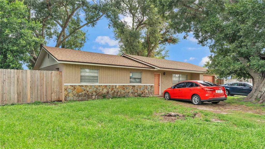 1612 High Point Ct SW, Winter Haven, FL 33880 - ranch-style home with fence, a front yard, and stone siding