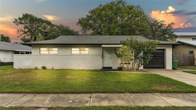 view of front of property with a garage and a yard